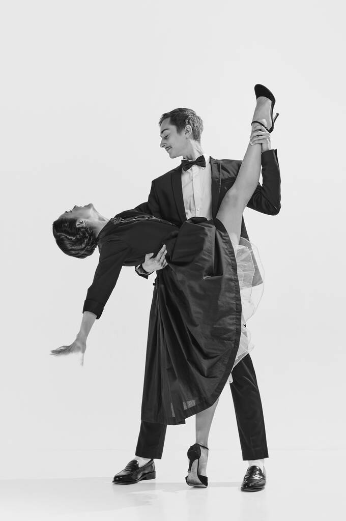 Elegantie en passie. Zwart op wit. Aantrekkelijke jonge vrouw en knappe man dansen lindy hop. Concept van hobby, retro dans, vintage stijl, choreografie, schoonheid. Monochrome kunst. Steun - Foto, afbeelding
