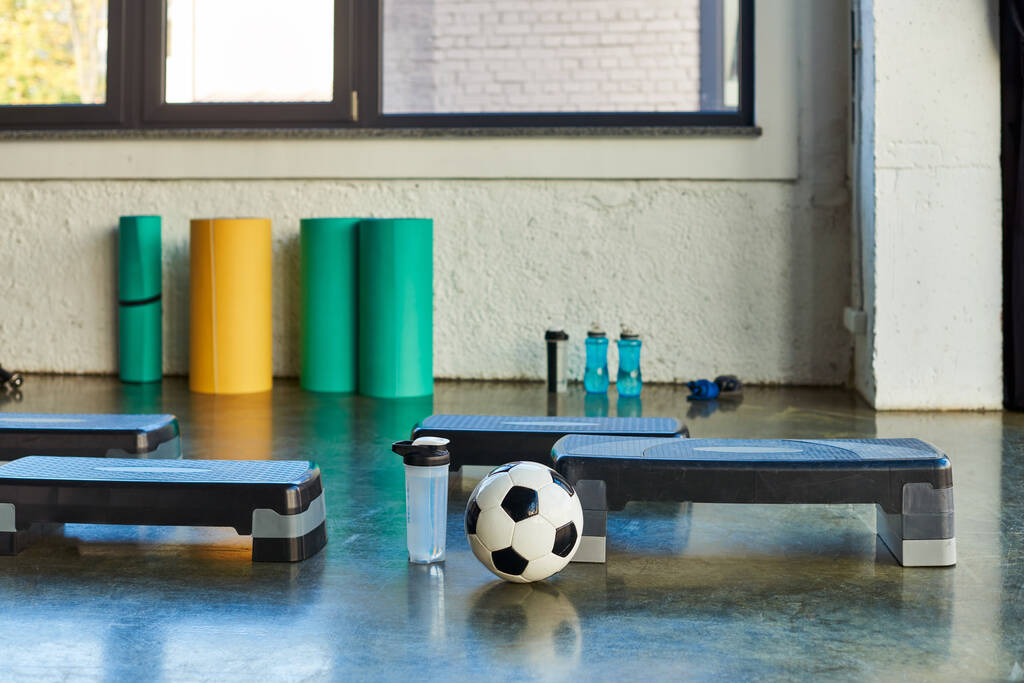 zdjęcie piłki nożnej i butelki wody obok fitness stepper na tle, koncepcja sportowa - Zdjęcie, obraz