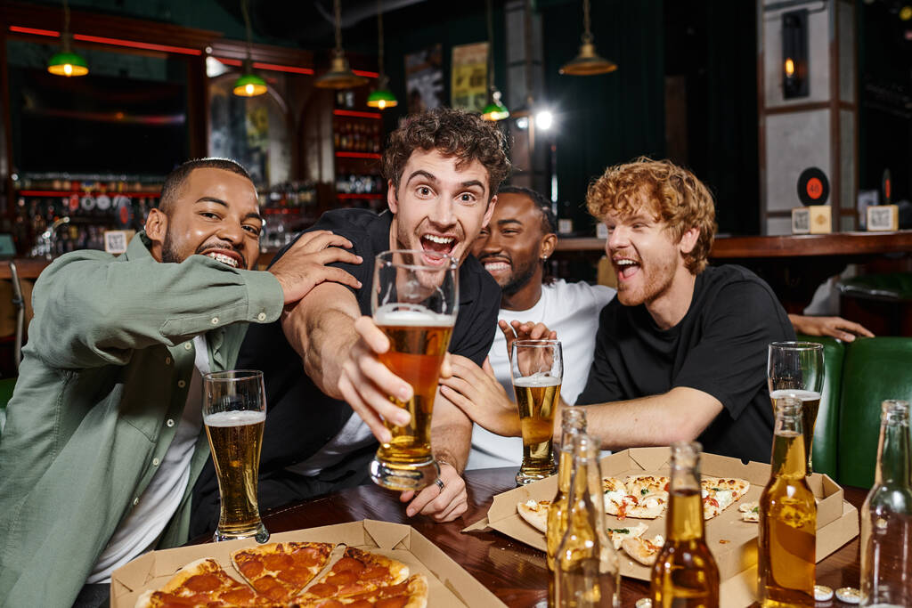 skupina nadšených multikulturních přátel tousty s sklenicemi piva v baru, muži na rozlučce se svobodou - Fotografie, Obrázek