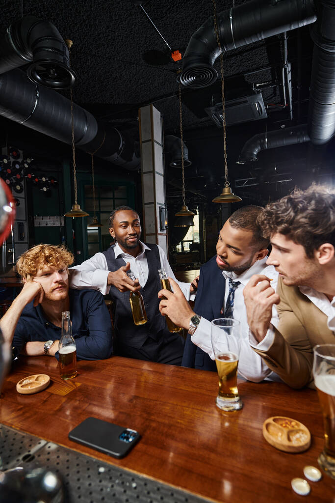 colegas borrachos en ropa formal charlando y bebiendo cerveza en el bar, pasar tiempo juntos después del trabajo - Foto, imagen