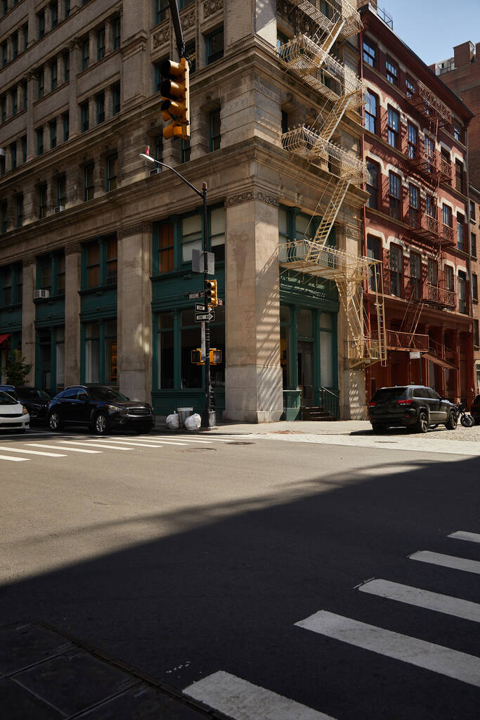 Eckgebäude mit Fluchttreppen und Autos an einer Kreuzung in der Innenstadt von New York - Foto, Bild