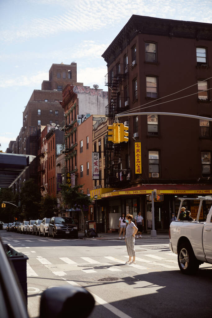 НЬЮ-ЙОРК, США - 26 ноября 2022 года: пешеходный переход с светофорами, автомобилями и пешеходами в азиатском квартале - Фото, изображение