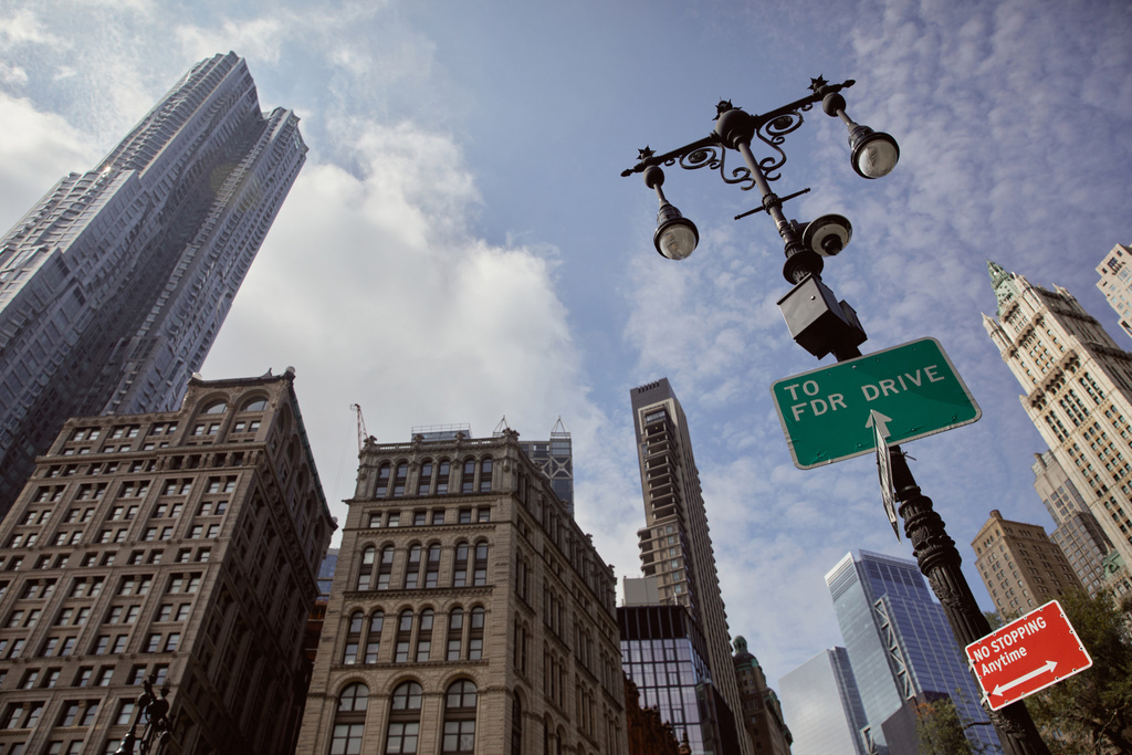straatpaal met lantaarns en verkeersborden tegen wolkenkrabbers in New York, laag hoekzicht - Foto, afbeelding