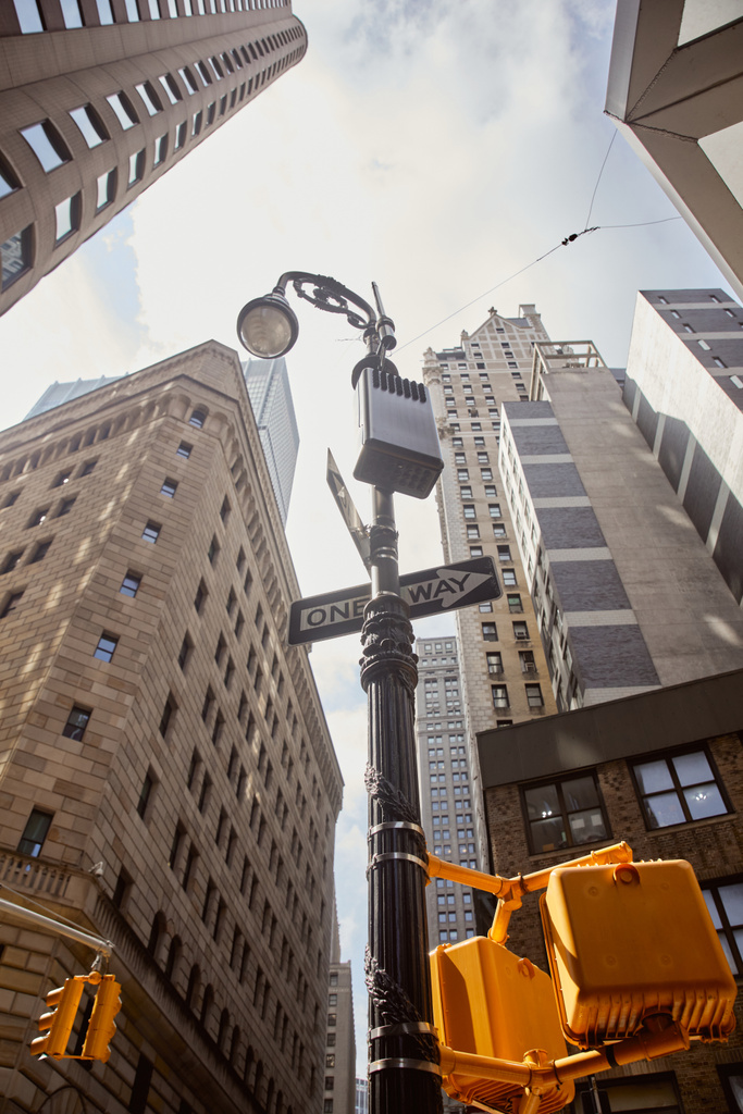 baixo ângulo vista de poste de rua com sinais de estrada e semáforos perto de edifício alto na cidade de Nova Iorque - Foto, Imagem