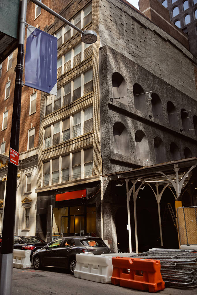 Duvarında taş dekoru olan tuğla binanın yanına park edilmiş arabalar. New York 'un yaratıcı mimarisi. - Fotoğraf, Görsel