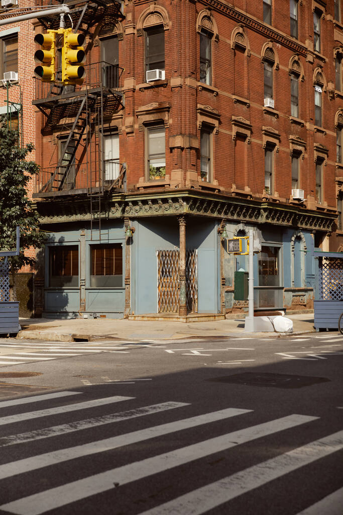 старинное здание с пожарной лестницей рядом с пешеходным переходом в городе Нью-Йорк, городская сцена - Фото, изображение