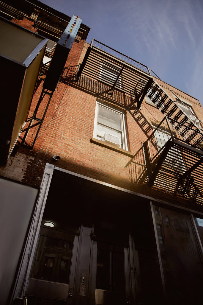 low angle view of red brick building with fire escape stairs in new york city, vintage architecture - Photo, Image