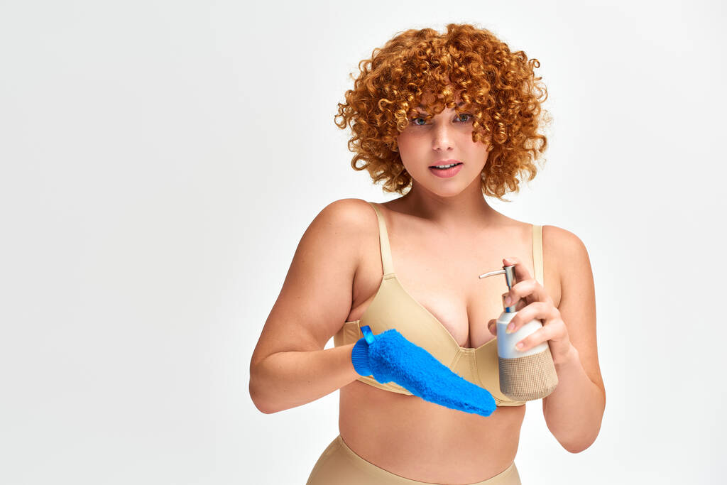 zrzka plus velikost žena v béžové spodní prádlo s koupací rukavicí a dávkovač tekutého mýdla na bílém - Fotografie, Obrázek