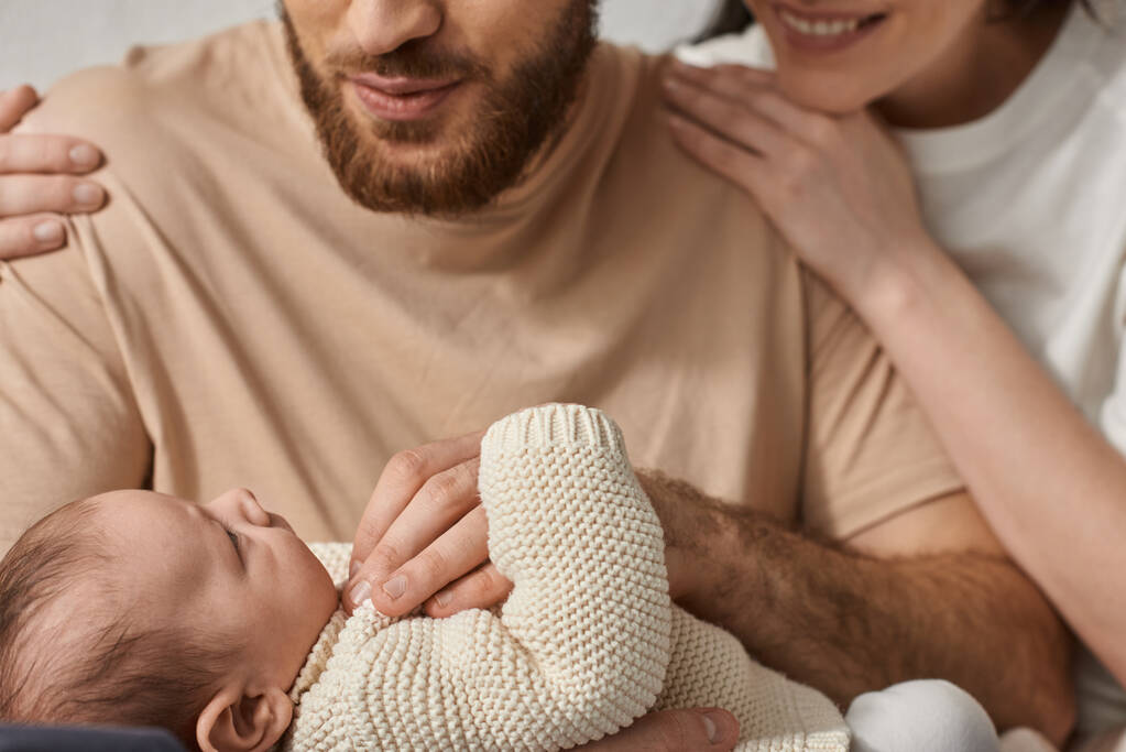 adorable nouveau-né couché dans les bras de ses parents joyeux et les regardant, concept de famille - Photo, image