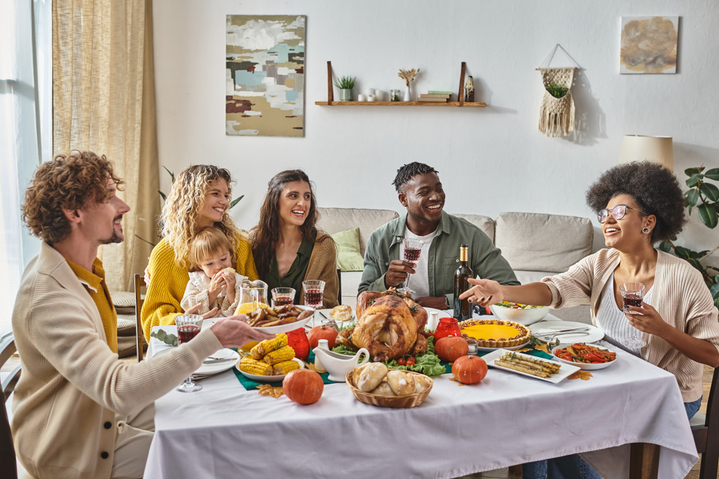 homme heureux passant plaque avec pommes de terre rôties à la femme afro-américaine pendant le dîner de Thanksgiving - Photo, image