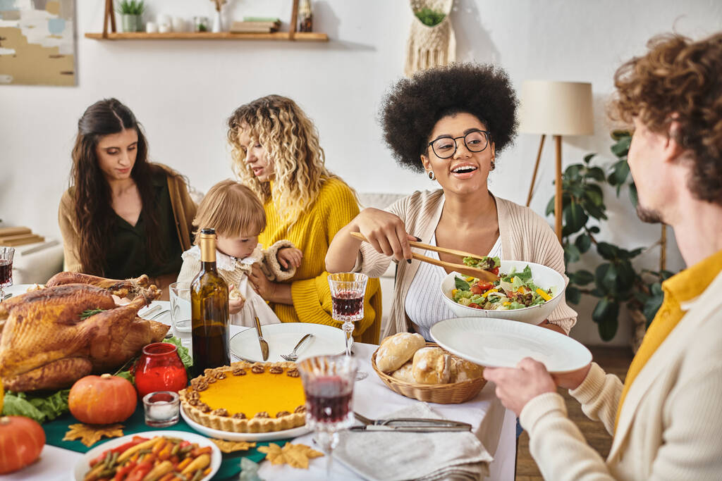 familia feliz disfrutando de una deliciosa cena mientras se reúnen en Acción de Gracias, pavo asado en la mesa - Foto, Imagen