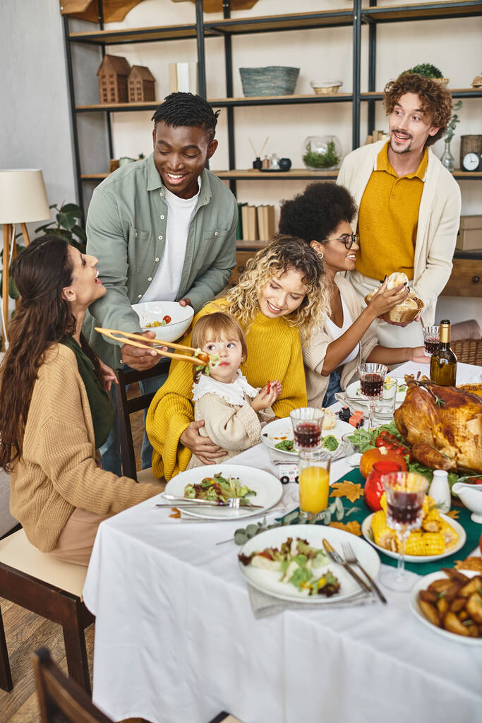 Happy Thanksgiving, cheerful multiethnic friends and family gathering at festive table with turkey - Photo, Image