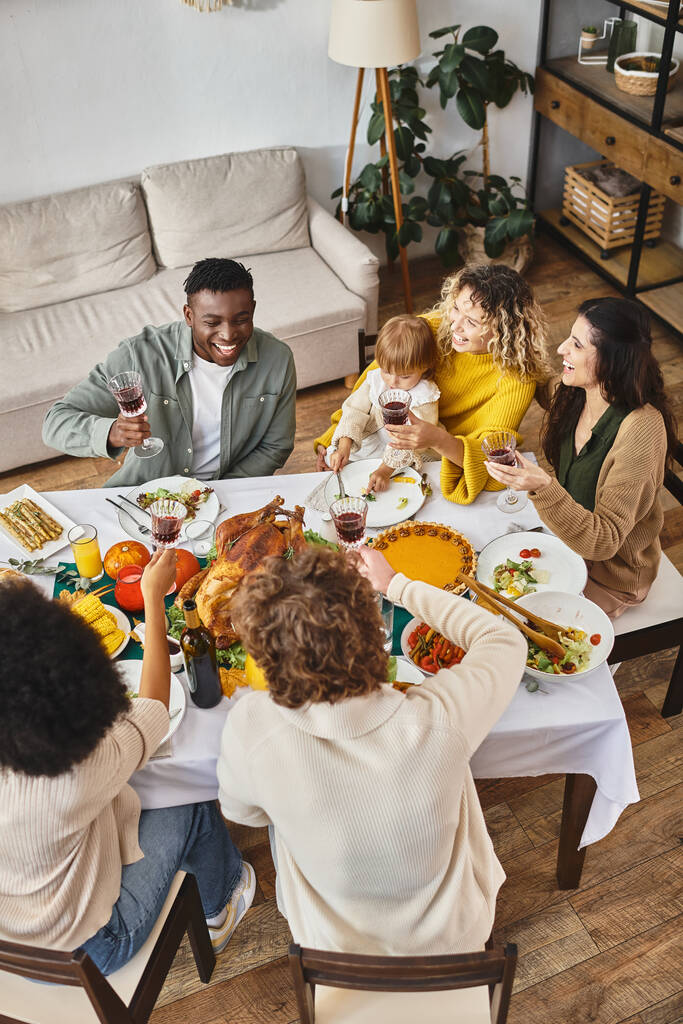 Šťastné Díkůvzdání, usmívající se multietničtí přátelé a rodinná jásot v blízkosti pečeného krocana, pohled shora - Fotografie, Obrázek