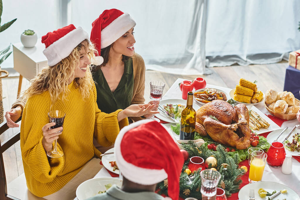 radostný pár Igbt sedí u vánočního stolu spolu s jejich multietnické rodiny mluví vesele - Fotografie, Obrázek