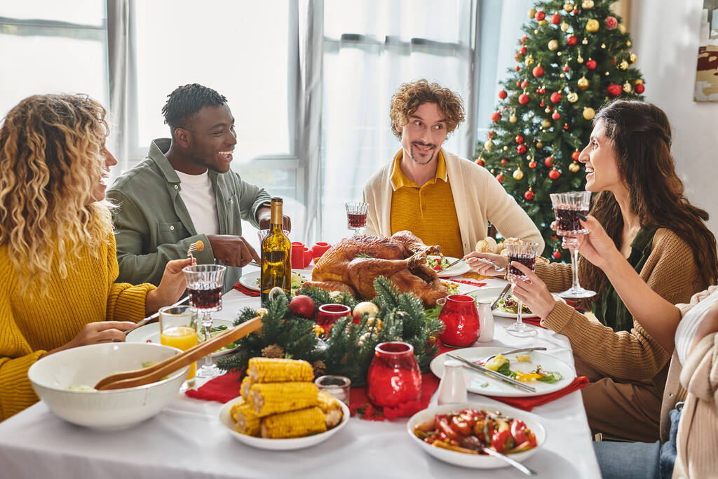 vidám, többnemzetiségű rokonok vidáman, és élvezik a karácsonyi lakomát pulykával és borral - Fotó, kép