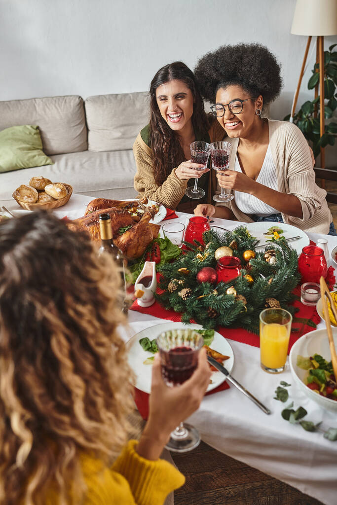 χαρούμενα μέλη της οικογένειας σε casual ενδυμασία μιλώντας με συγγενείς που κάθονται στο γιορτινό τραπέζι, Χριστούγεννα - Φωτογραφία, εικόνα