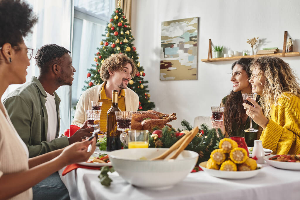 μεγάλη πολυπολιτισμική οικογένεια που περνάει καλά γιορτάζοντας τα Χριστούγεννα και απολαμβάνοντας εορταστικό γεύμα - Φωτογραφία, εικόνα