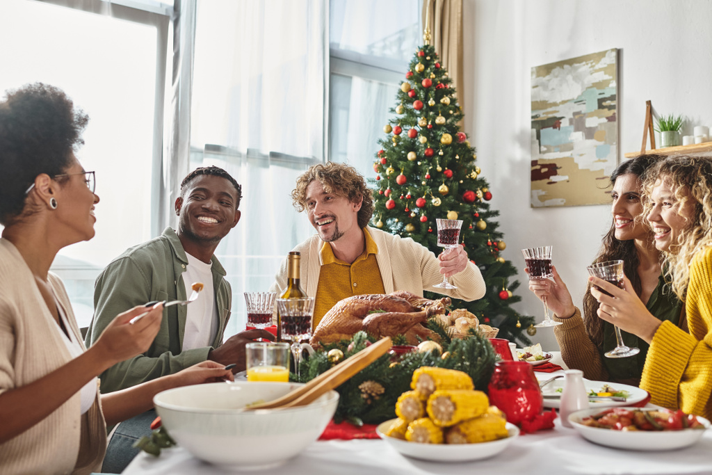 vidám, többnemzetiségű család, akik jól érzik magukat ünnepi ebéd emelt boros poharakkal, Karácsony - Fotó, kép