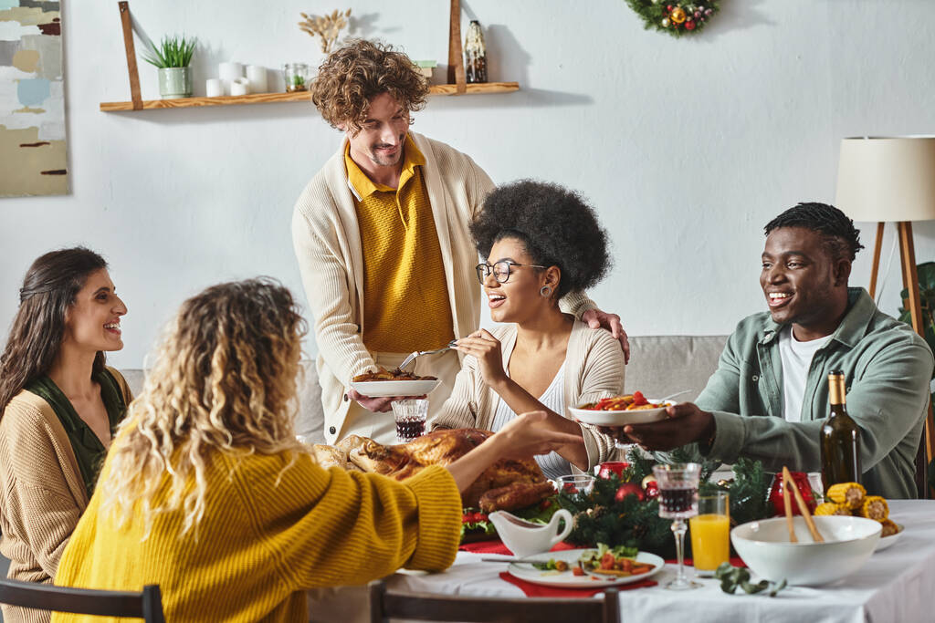 onnellinen monikulttuurinen perhe istuu juhlapöydässä jakaa ruokaa ja juoda viiniä, joulu - Valokuva, kuva