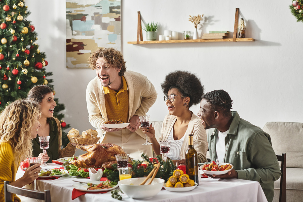 vrolijke multiraciale familie hebben veel plezier op feestelijke lunch drinken van wijn en het eten van kalkoen, Kerstmis - Foto, afbeelding