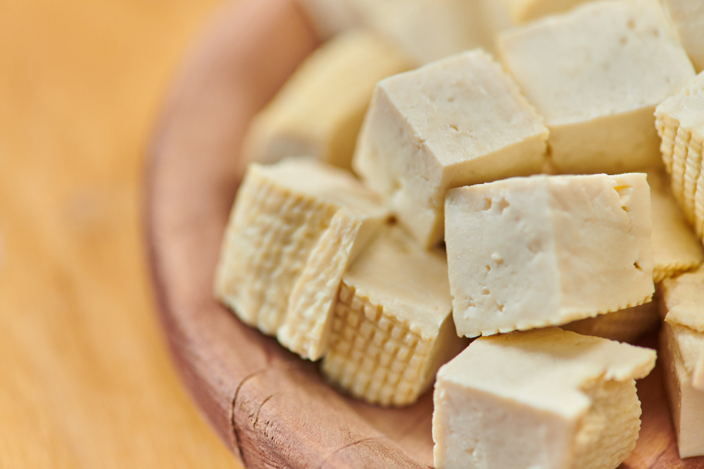 közeli kilátás kockázott finom tofu sajt fából készült tányéron, finom vegetáriánus étrend koncepció - Fotó, kép