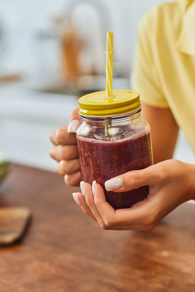 cropped view of woman with refreshing smoothie in mason jar with straw, plant-based diet concept - Photo, Image