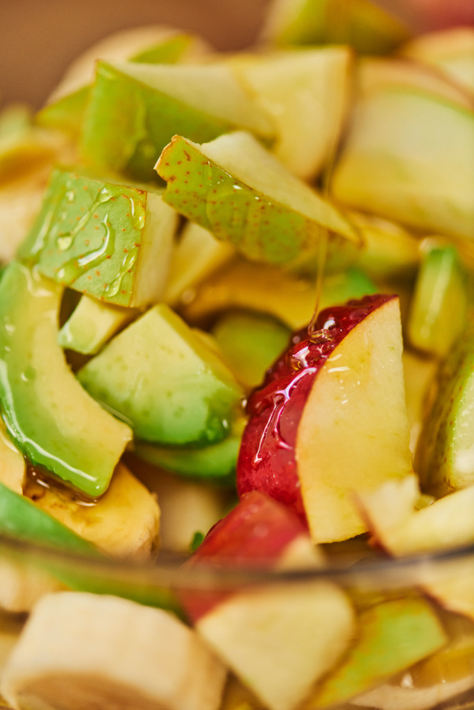 蜂蜜,ベジタリアン背景とリンゴ,梨,アボカドと美味しいフルーツサラダのクローズアップ - 写真・画像
