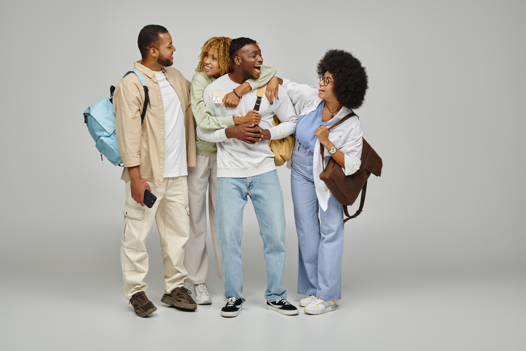 alegres amigos afroamericanos abrazándose calurosamente y sonriéndose, estilo de vida estudiantil - Foto, imagen