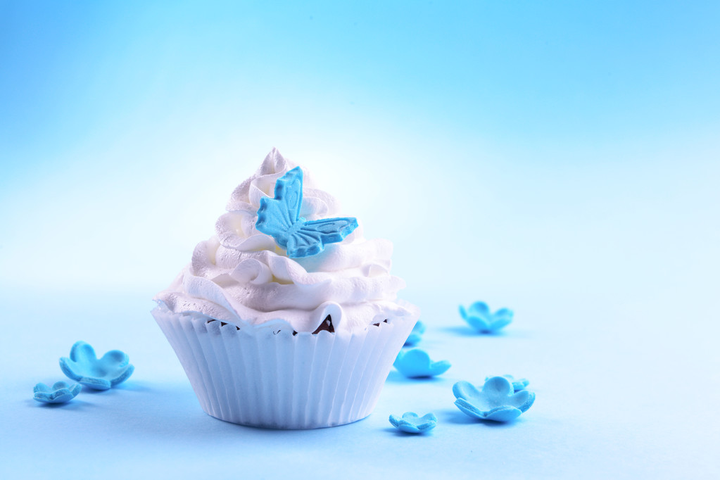 Delicioso cupcake sobre fondo azul
 - Foto, imagen