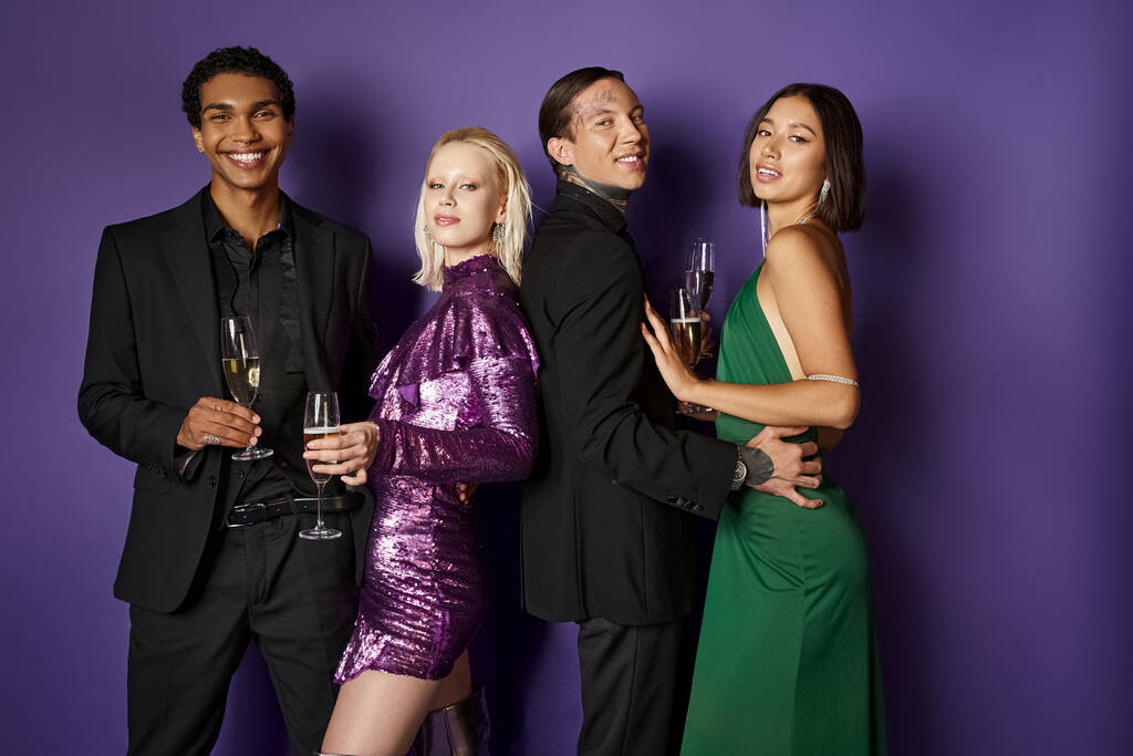 Vánoční večírek, šťastné multietnické páry ve svátečních šatech se sklenicemi šampaňského na fialové - Fotografie, Obrázek
