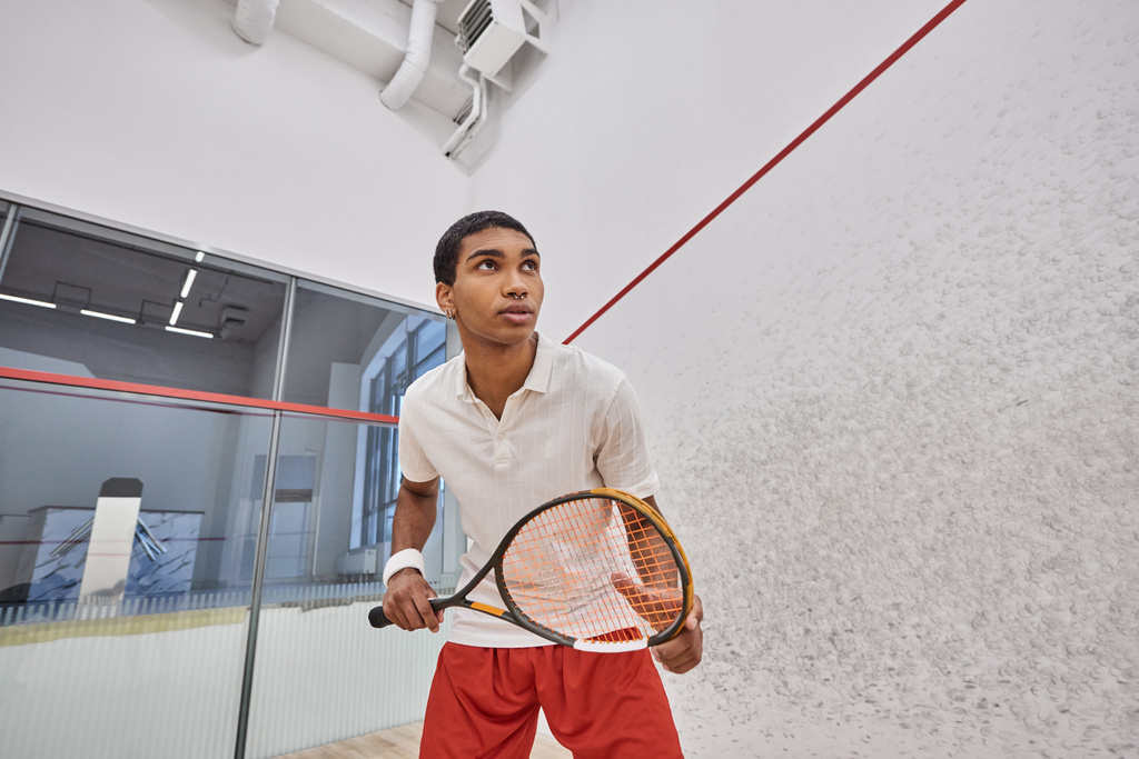 athletische afrikanisch-amerikanische Mann hält Squash-Schläger, während Spiel innerhalb des Gerichts - Foto, Bild