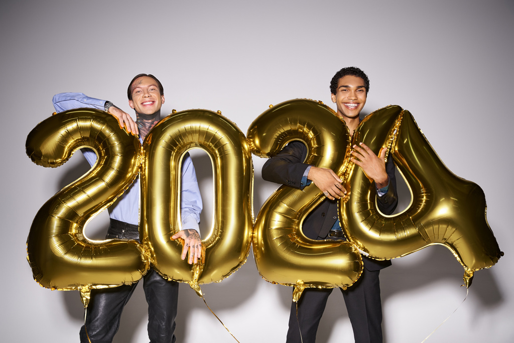 щасливі міжрасові друзі-чоловіки, що тримають повітряні кулі з 2024 номерами під час вечірки, концепція Нового року - Фото, зображення