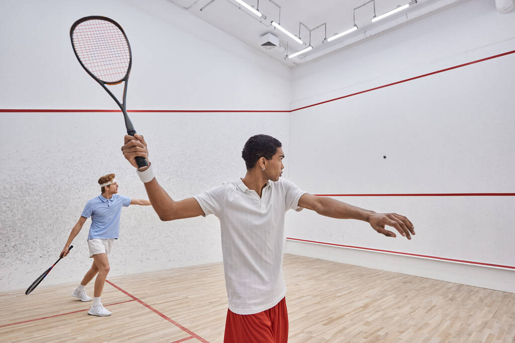 Spor giyim sektöründeki ırklar arası oyuncular saray içinde squash oynuyorlar, aktif bir yaşam tarzı. - Fotoğraf, Görsel