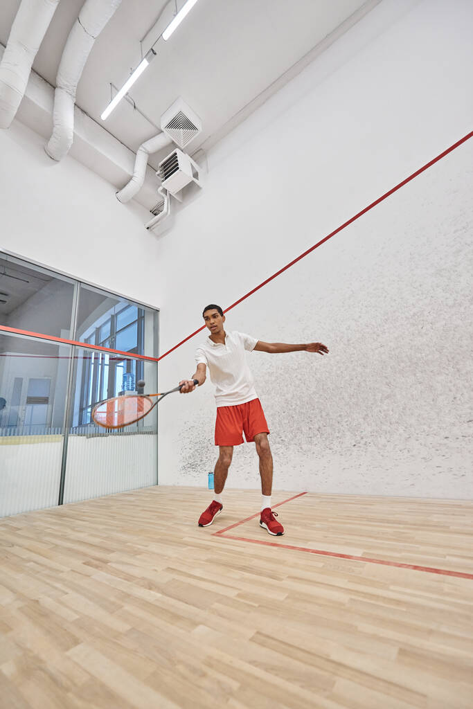junger afrikanisch-amerikanischer Sportler beim Squash auf dem Court, Herausforderung und Motivation - Foto, Bild