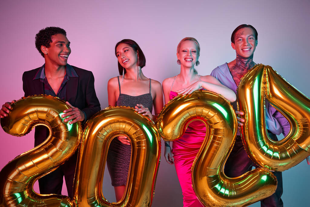 Frohes Neues Jahr, fröhliche Freunde in festlicher Kleidung mit Luftballons mit 2024-Nummern - Foto, Bild