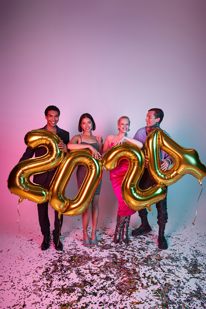 新年のコンセプト,パープルピンクの2024数字の風船を持っている幸せな多民族の友人 - 写真・画像