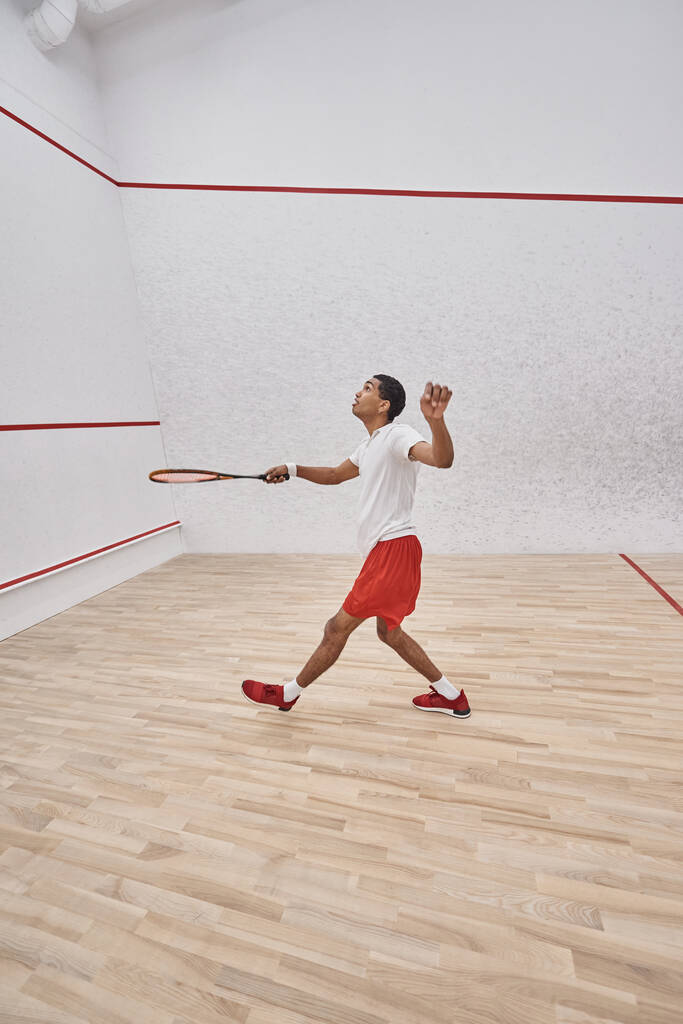 liike laukaus, energinen afrikkalainen amerikkalainen urheilija maila pelaa squash oikeudessa, kilpailu - Valokuva, kuva