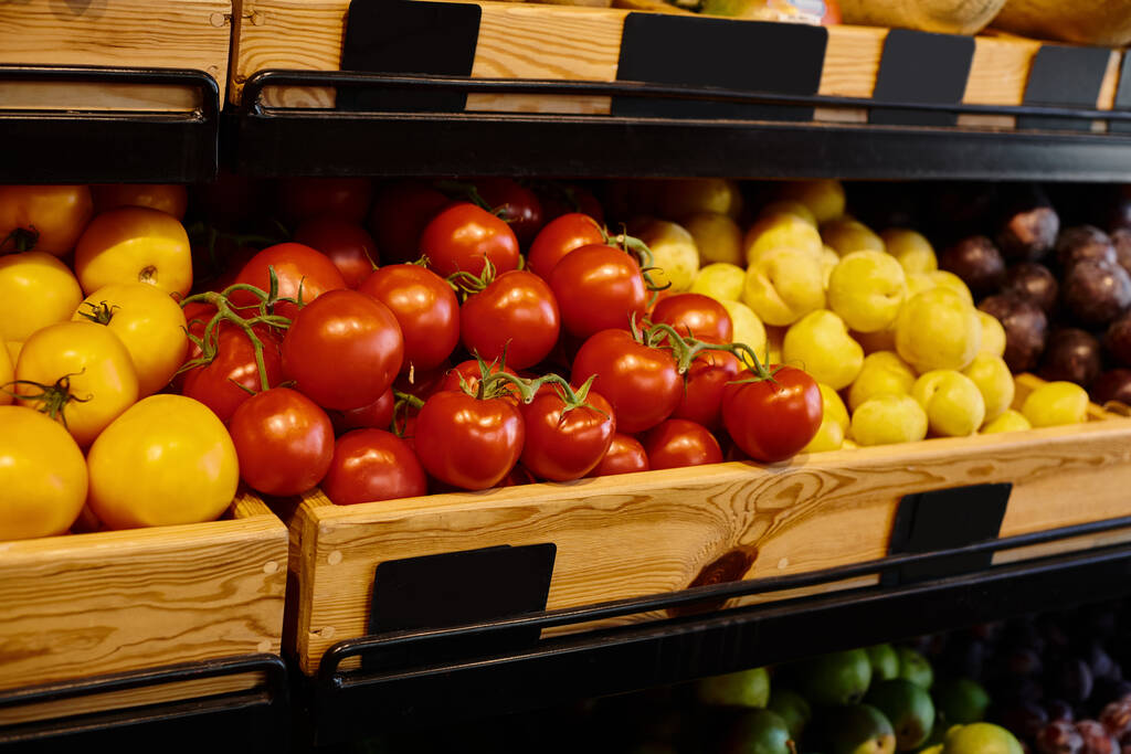 Objektfoto eines hellen Gemüsestandes mit frischen roten und gelben Tomaten im Lebensmittelgeschäft, niemand - Foto, Bild
