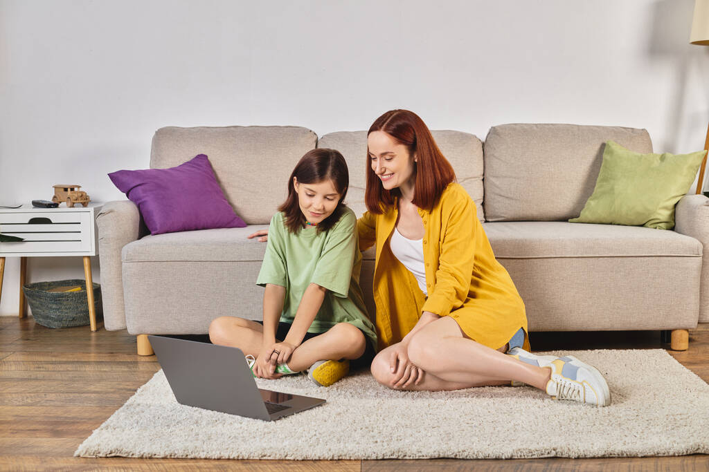 mosolygós anya és tizenéves lánya néz filmet laptop padlón a nappaliban, szabadidő - Fotó, kép