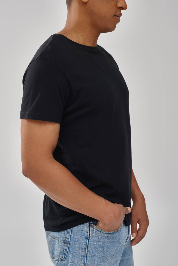 modelo masculino afroamericano elegante posando en camiseta negra y pantalones vaqueros, espacio de copia para la publicidad - Foto, Imagen