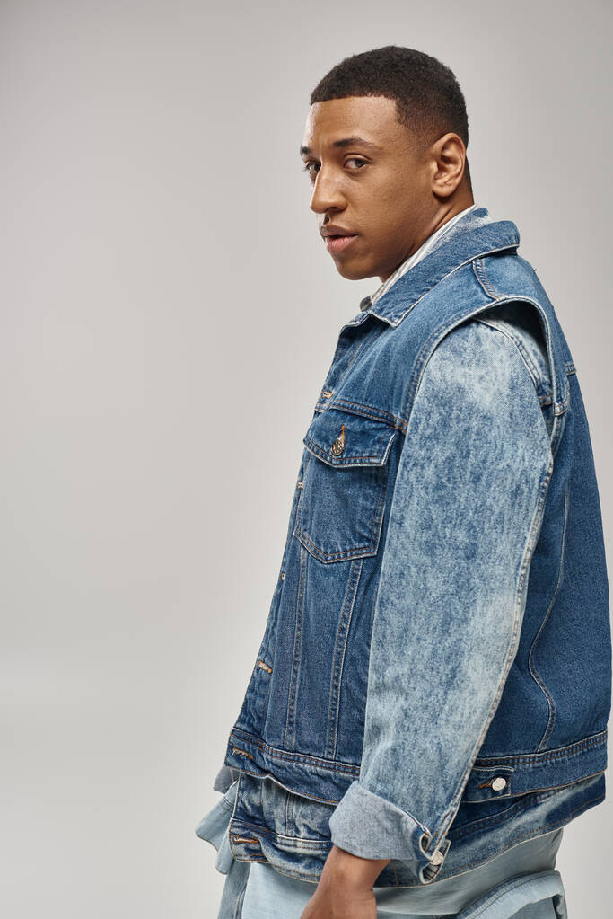 добре виглядає афроамериканський чоловік у стильному джинсовому вбранні, що позує в русі, концепція моди - Фото, зображення