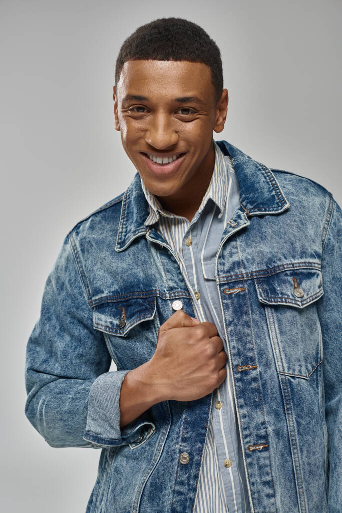 young trendy african american man in stylish denim outfit posing on white backdrop, fashion - Photo, Image