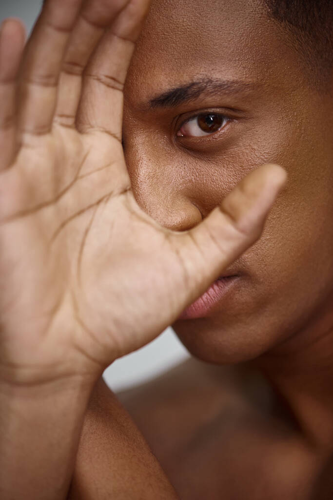 close up de belo atraente homem afro-americano com a mão na frente da cara, conceito de moda - Foto, Imagem