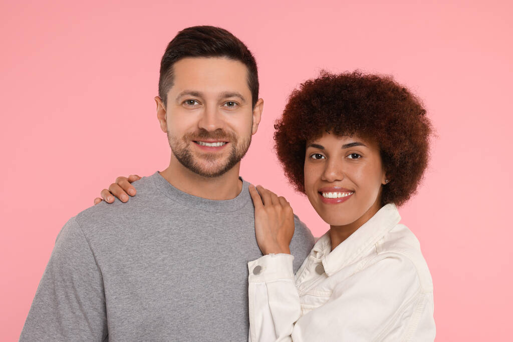 Internationale Partnervermittlung. Porträt eines schönen Paares auf rosa Hintergrund - Foto, Bild