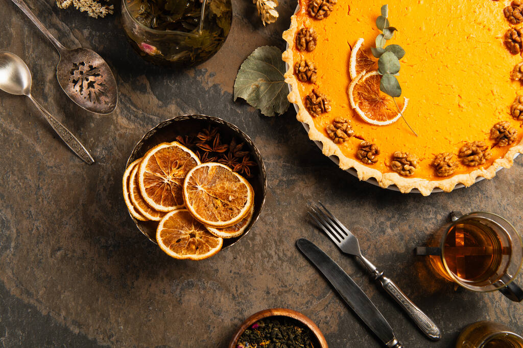 φόντο ευχαριστιών με νόστιμη κολοκυθόπιτα, vintage μαχαιροπίρουνα και φέτες πορτοκαλιού σε πέτρινο τραπέζι - Φωτογραφία, εικόνα