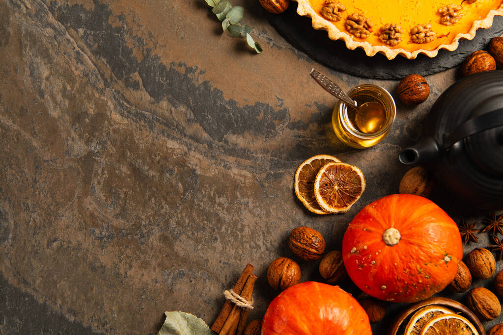деревенский День благодарения натюрморт, спелые тыквы рядом с медом и вкусный тыквенный пирог на текстурной поверхности - Фото, изображение