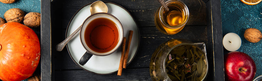 wooden tray with herbal tea and aromatic honey near autumnal items, thanksgiving concept, banner - Photo, Image