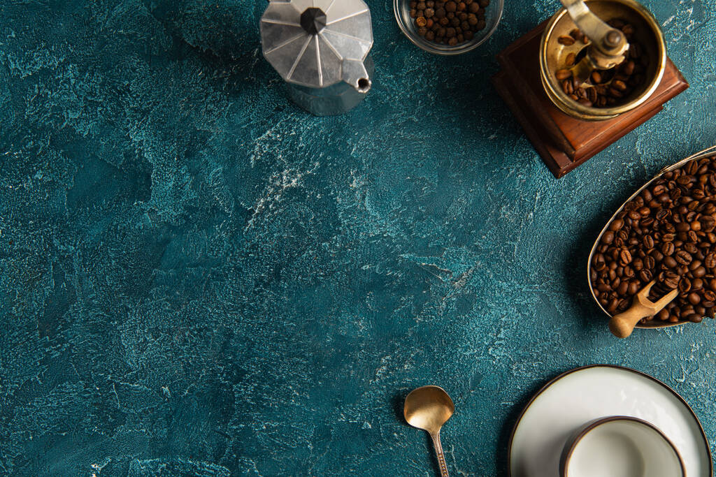Erntedank-Feiertagsmorgen, Kaffeebohnen, Handmühle und Geysirkanne auf blau strukturierter Oberfläche - Foto, Bild