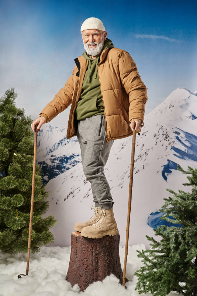 urheilullinen mies seisoo kanto ja tilalla hiihtopylväät hymyillen kameran edessä, talvi käsite - Valokuva, kuva