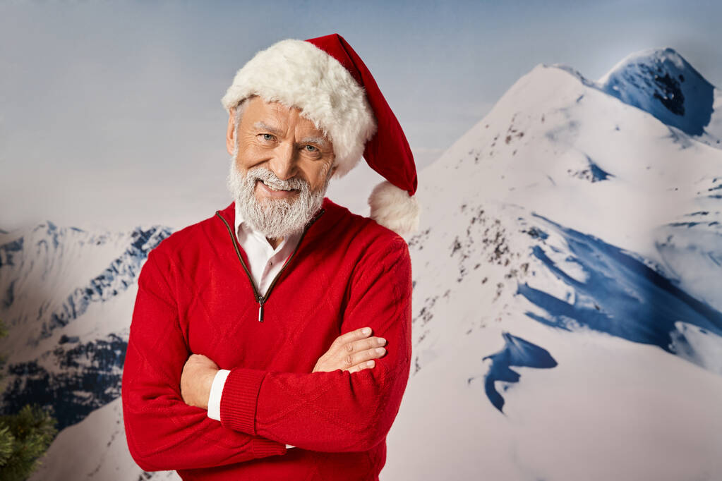 fröhlicher Mann im Weihnachtsmannkostüm, der mit verschränkten Armen auf der Brust in die Kamera lächelt, Winterkonzept - Foto, Bild